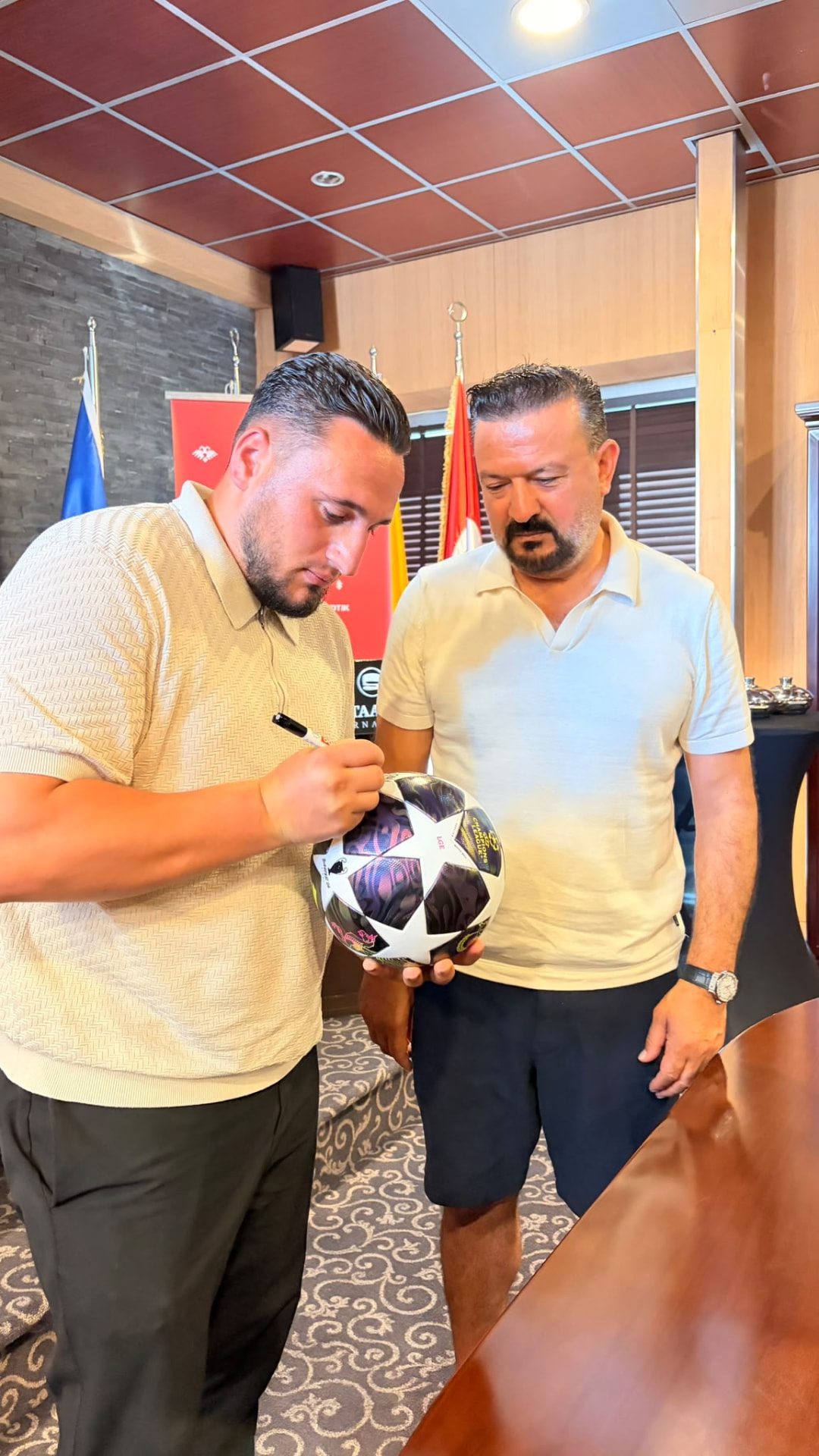 Ballieman signeert een voetbal tijdens een samenwerking